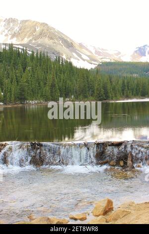 Un lac de montagne froide se cascade sur un barrage de castor Banque D'Images