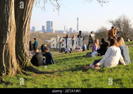 Les gens profitent d'un soleil d'hiver chaud et de la vue sur Primrose Hill, dans le nord de Londres, au Royaume-Uni Banque D'Images