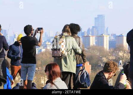 Personnes regardant la vue sur la ville sous le soleil d'hiver sur Primrose Hill, dans le nord de Londres, Royaume-Uni Banque D'Images