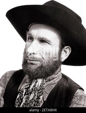 HOMME DES ANNÉES 1930 HORS-LA-LOI PORTANT UN CHAPEAU DE COW-BOY NOIR ET UNE BARBE SOMBRE GILET À MOUCHOIR RUGUEUX ET PRÊT POUR L'EXPRESSION FACIALE - C569 HAR001 HARS ENTERTAINMENT EBAUCHE GILET EXPRESSIONS B&W TRISTESSE GARS MOUSTACHE ARTS DE LA SCÈNE TENTATION TÊTE ET ÉPAULES PERFORMANCE FORCE MOUSTACHES ET EXCITATION NECKERCHIER ENTERTAINER PROFESSIONS DE CHEVEUX FACIAUX ACTEURS CONCEPTUELS AMUSEURS MILIEU-ADULTE HOMME MI-ADULTE ARTISTES HORS-LA-LOI JEUNE ADULTE HOMME NOIR ET BLANC ORIGINE ETHNIQUE CAUCASIENNE HAR001 OLD FASHIONED SÉVÈRE Banque D'Images