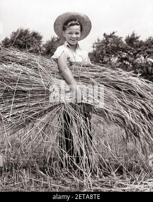 GARÇON DE FERME SOURIANT DES ANNÉES 1930 PORTANT UN CHAPEAU DE PAILLE TENANT UNE GERBE DE BLÉ DE COUPE REGARDANT LA CAMÉRA - F1604 HAR001 HARS GARÇONS CONFIANCE AGRICULTURE B&W BLÉ ÉTÉ OBJECTIFS DE CONTACT AVEC LES YEUX BONHEUR EXCITATION GAIE FERMIERS FIERTÉ DES OCCUPATIONS SAINES SOURIRES JOYEUSE COOPÉRATION JEUNES PRÉ-ADOLESCENCE PRÉ-SAISON DES GARÇONS NOIR ET BLANC RACE BLANCHE HAR001 DÉMODÉE Banque D'Images