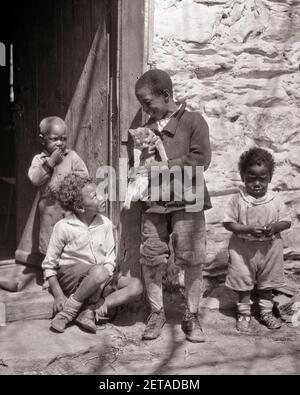 ANNÉES 1930 QUATRE ENFANTS AFRO-AMÉRICAINS GARÇONS À LA PORTE POUR EN LOGER UN TITULAIRE D'UN TABBY DOMESTIQUE CAT - N959 HAR001 FAMILLES HARS STYLE DE VIE MAISONS FRÈRES PAUVRES VIE RURALE MAISON ÉTATS-UNIS COPIE ESPACE AMITIÉ PLEINE LONGUEUR RÉSIDENTIEL ÉTATS-UNIS D'AMÉRIQUE MÂLES ANIMAUX DE COMPAGNIE BÂTIMENTS FRÈRES ET SŒURS B&W AMÉRIQUE DU NORD AMÉRIQUE DU NORD TABBY BONHEUR MAMMIFÈRES AFRO-AMÉRICAINS EXTÉRIEUR AFRO-AMÉRICAIN FÉLINE L'ETHNICITÉ NOIRE DU SUD-EST FIERTÉ DES RELATIONS ENTRE LES MAISONS LA RÉSIDENCE APPARENTÉE AU SUD DÉSAVANTAGEAIT LE BÉBÉ GARÇON FÉLINS LA COOPÉRATION DÉSAFFECTÉE DÉÇU DÉCONNECTÉ DES JUVÉNILES APPAUVRIS PETIT MAMMIFÈRE Banque D'Images