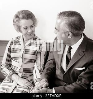 ANNÉES 1960, COUPLE SENIOR MATURE DES ANNÉES 1970 ASSIS SUR UN CANAPÉ TENANT LES MAINS SE REGARDANT LES UNS LES AUTRES - S17184 HAR001 HARS FEMMES ÂGÉES CONJOINT MARIÉ ÉPOUX MAISON VIE COPIE ESPACE AMITIÉ DEMI-LONGUEUR DAMES PERSONNES S'OCCUPANT HOMMES RETRAITE SENIOR HOMME SENIOR ADULTE PARTENAIRE B&W. FEMME SÉNIOR RETRAITÉ BONHEUR VIEILLESSE OLDSTERS GAIE GRAND ANGLE OLDSTER TENANT LES MAINS SOURIT AUX AÎNÉS JOYEUX ATTACHEMENT PERSONNEL AFFECTION ÉMOTION TOGETHERNESS ÉPOUSES NOIR ET BLANC DE RACE BLANCHE HAR001 OLD FASHIONED Banque D'Images