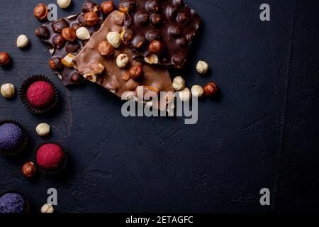 Truffe de bonbons au chocolat avec morceaux de chocolat et poudre de cacao volant sur fond sombre Banque D'Images