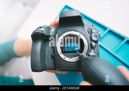 Gros plan du capteur de la caméra de nettoyage avec un aspirateur, un ventilateur d'air ou une pompe à vide. Entretien de l'équipement de photographie Banque D'Images