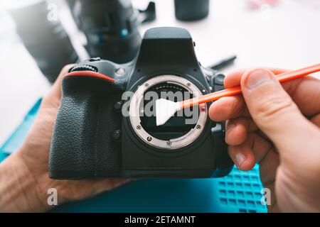 Le photographe nettoie la matrice de son appareil photo à l'aide d'un nettoyant pour capteur d'appareil photo ou d'un écouvillon de nettoyage. Entretien de l'équipement de photographie Banque D'Images