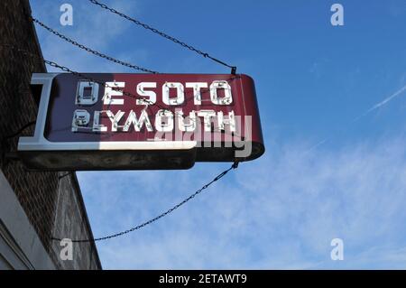 Un panneau publicitaire rétro DeSoto et Plymouth Neon est accroché à l'extérieur de l'ancien bâtiment de G&E tire Company, dans la ville de Carthage, au Missouri, sur la route 66. Banque D'Images