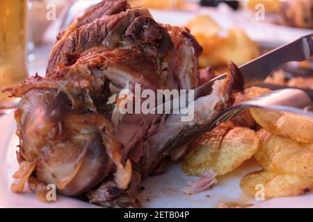Manger un porte-jarret de porc rôti avec des frites Banque D'Images