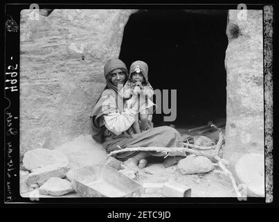 Pétra. Types Petrean, etc. Bdul Bedouins. Mère et bébé avant leur maison de grotte dans la vallée d'ed-Dêr Banque D'Images
