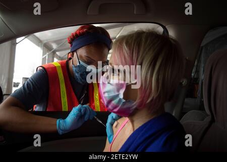 Atlanta, Géorgie, États-Unis. 1er mars 2021. Une femme de 63 ans dont le système immunitaire est affaibli reçoit le premier des deux vaccins Pfizer contre le virus COVID-19 à un site de vaccination de masse dans un lot de Delta Airlines près de l'aéroport de AtlantaÃs Hartsfield-Jackson. Credit: Robin Rayne/ZUMA Wire/Alay Live News Banque D'Images