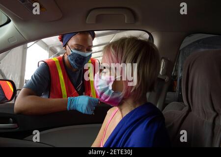 Atlanta, Géorgie, États-Unis. 1er mars 2021. Une femme de 63 ans dont le système immunitaire est affaibli reçoit le premier des deux vaccins Pfizer contre le virus COVID-19 à un site de vaccination de masse dans un lot de Delta Airlines près de l'aéroport de AtlantaÃs Hartsfield-Jackson. Credit: Robin Rayne/ZUMA Wire/Alay Live News Banque D'Images