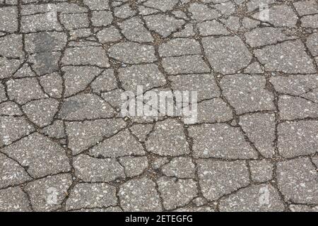 Gros plan de la surface de la route asphaltée fissurée Banque D'Images