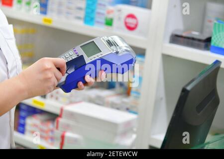 Effectuer des achats, Payer avec une carte de crédit et utiliser un terminal sur de nombreux médicaments en arrière-plan de pharmacie. Banque D'Images