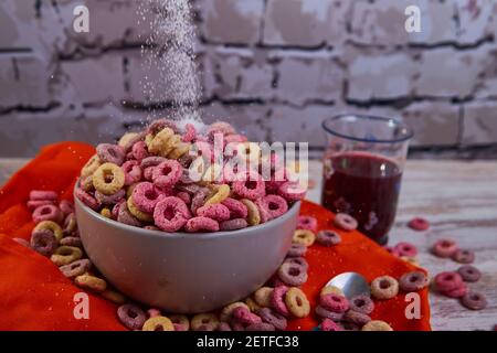 mauvais petit déjeuner de céréales de couleur tombant de sucre avec des fruits rouges jus Banque D'Images