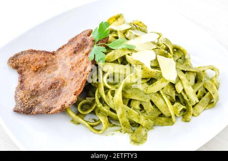 Le Tallarin Verde con Bistec est un plat péruvien célèbre. C'est du pesto spaghetti avec un steak froissé. Banque D'Images