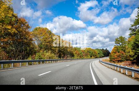 Route sinueuse et colorée du Massachusetts bordée de rouge et les mauves jaunes d'automne invitent le voyageur sur un inoubliable voyage a Banque D'Images