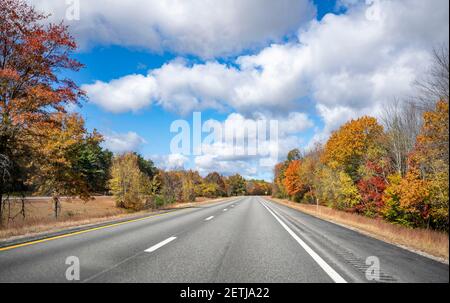 Route sinueuse et colorée du New Hampshire bordée de des érables d'automne rouges et jaunes invitent le voyageur à un un voyage inoubliable Banque D'Images