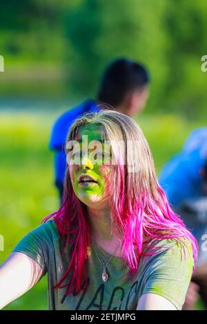 Russie, Moscou - 25 juin 2017. Portrait d'une fille avec des fleurs brillantes sur son visage. Rires avec bonheur. Holi est un séjour traditionnel en Inde Banque D'Images