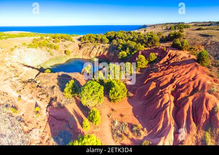 Roches rouges de la carrière de bauxite abandonnée mine et lac, vue aérienne, Otrante, province de Lecce, Apulia, Italie Banque D'Images