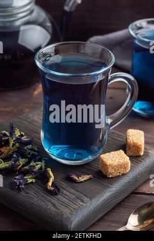 Thé thaï bleu anchan de bourgeons klitoria Ternate dans une tasse de verre, fond sombre Banque D'Images