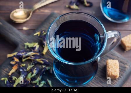 Thé thaï bleu anchan de bourgeons klitoria Ternate dans une tasse de verre, fond sombre Banque D'Images