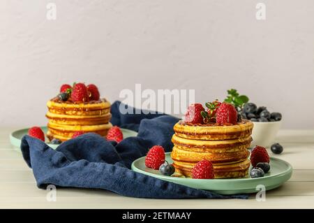 Crêpes américaines savoureuses aux framboises, aux bleuets et au miel. Banque D'Images