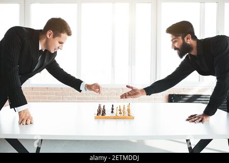 deux hommes d'affaires, rivaux, jouent aux échecs. Stratégie et rivalité. Banque D'Images