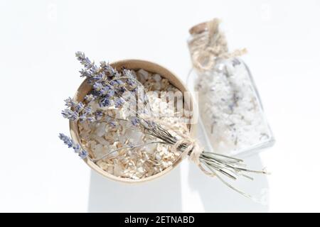 Sel de mer dans un pot en verre avec bouchon en liège. Produits de spa pour les soins de la peau et pour un bain relaxant sur fond blanc avec un petit bouquet de lavande Banque D'Images