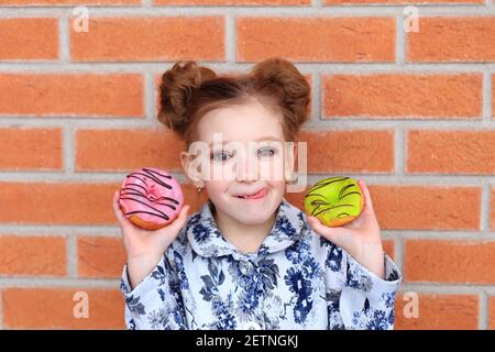 portrait d'un enfant avec un donut entre ses mains Banque D'Images