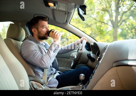 Un jeune homme charmant aime son café tout en naviguant à travers le bois Banque D'Images