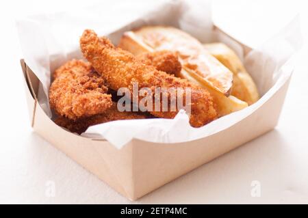 les doigts de poulet panés et les frites dans un récipient à emporter Banque D'Images