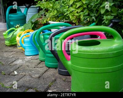 arrosoirs colorés dans le jardin Banque D'Images