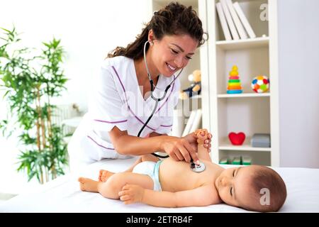Bébé couché sur le dos pendant que son médecin l'examine lors d'un contrôle médical standard Banque D'Images