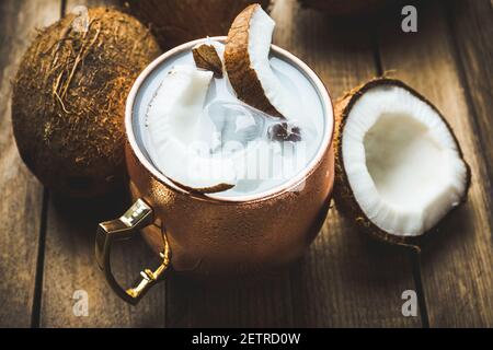 Doux cocktail de noix de coco dans une tasse de cuivre (variante de mule de Moscou) sur fond de bois. Mise au point sélective. Faible profondeur de champ. Banque D'Images