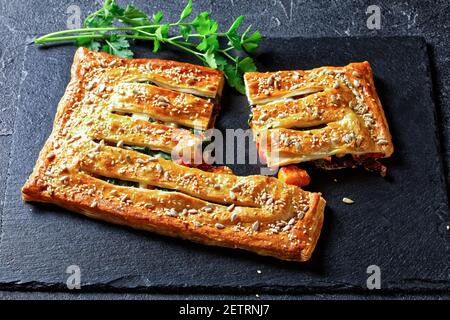 Pâte feuilletée tarte aux légumes avec fromage de chèvre et graines de tournesol grillées et de sésame fourrées de légumes rôtis : tomates, oignons et potiron Banque D'Images