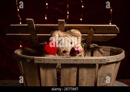 Adorable ours en peluche fait main avec un coeur en bois et un rose pâle Banque D'Images