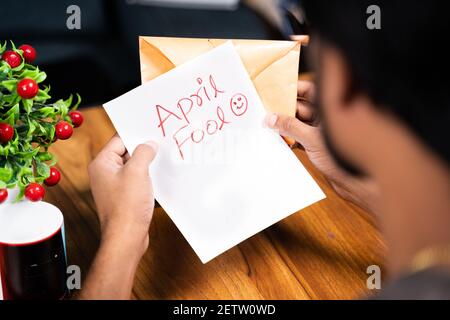 Prise de vue à l'épaule d'un jeune homme qui reçoit la queue - concept d'avril fools jour a fait un tour en envoyant une lettre surprise, après l'ouverture mentionné en avril Banque D'Images