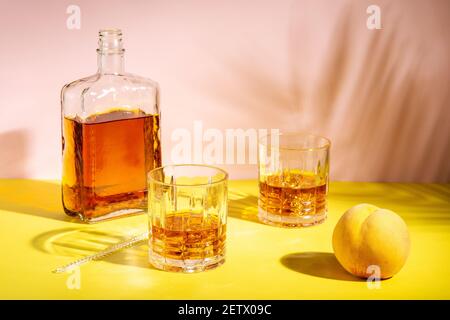 Le rhum ou l'Amaretto s'aigre avec de la glace dans un verre sur un fond lumineux. Concept de fête d'été. Banque D'Images