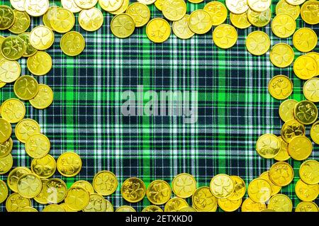Toile de fond de la St Patrick, pièces de monnaie dorées avec shamrock sur le tissu à carreaux verts, concept de la St Patricks Day, bordure de la St Patricks Day Banque D'Images