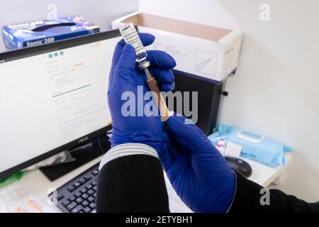 Une paire de gants portée par un pharmacien du sud de Londres prépare un jab AstraZenica Covid-19 par seringue pour la vaccination d'une personne locale lors du troisième confinement de la pandémie du coronavirus, le 2 mars 2021, à Londres, en Angleterre. Banque D'Images