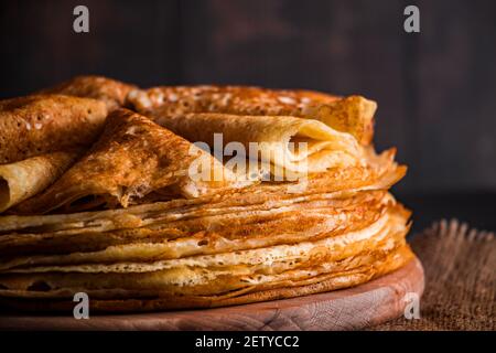 Une pile de crêpes fines sur un fond en bois sombre de gros plan. Un plat traditionnel de crêpes pour les vacances Maslenitsa. Place pour votre texte, photo pour Banque D'Images