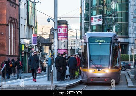 Les navetteurs tôt le matin et le tramway LUAS dans le quartier financier, Dublin, Irlande Banque D'Images