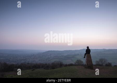 Bath, Royaume-Uni. 1er mars 2021. Un homme admirant un spectaculaire coucher de soleil gelé sur Bath depuis Solsbury Hill. Crédit : BC/Alay Live News Banque D'Images