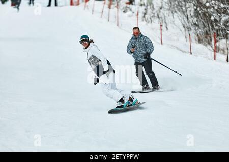 Skieur de descente. Les snowboarders et les skieurs se délaguent sur la neige dans les montagnes. Descente. Saison des skieurs d'aventure. Stations de ski et de snowboard. Ski et Banque D'Images