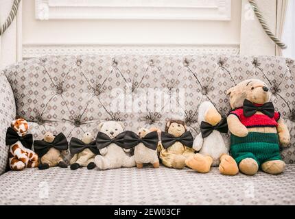 Les teddies d'enfance sont alignées sur un canapé Banque D'Images