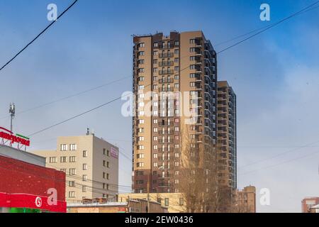 Chelyabinsk, Russie - 14 novembre 2020. Architecture urbaine, immeuble résidentiel de plusieurs étages, éclairé par la lumière du soleil, contre le ciel. Banque D'Images