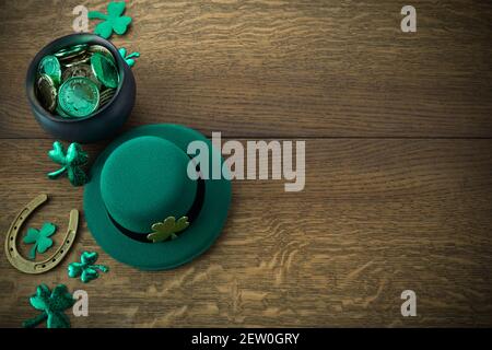 St Patrick bordure de la journée de shamrock, pièces d'or et chapeau de leprechaun sur fond rustique en bois Banque D'Images