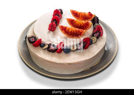 cheesecake avec des tranches d'orange et des morceaux de framboise et de myrtille, tarte entière isolée sur blanc Banque D'Images