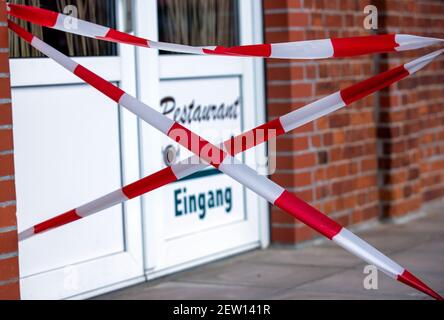 Boizenburg, Allemagne. 02 mars 2021. L'entrée d'un restaurant du port est barrée de ruban barrière rouge et blanc. En raison des mesures de protection de Corona, les restaurants et les cafés sont fermés depuis des mois. Credit: Jens Büttner/dpa-Zentralbild/dpa/Alay Live News Banque D'Images