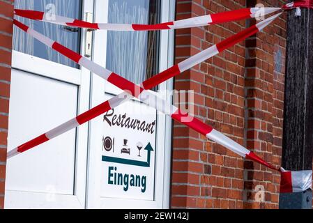 Boizenburg, Allemagne. 02 mars 2021. L'entrée d'un restaurant du port est barrée de ruban barrière rouge et blanc. En raison des mesures de protection de Corona, les restaurants et les cafés sont fermés depuis des mois. Credit: Jens Büttner/dpa-Zentralbild/dpa/Alay Live News Banque D'Images